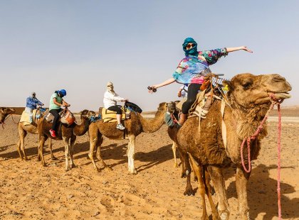 Travellers riding camels in Sahara Desert, Morocco
