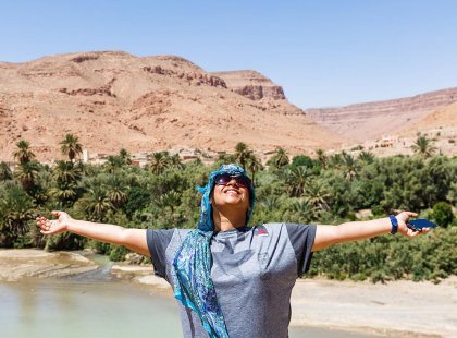 Happy traveller spreading arms, Todra Gorge, Morocco