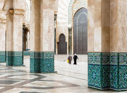 Local women walking through archways of Hassan II Mosque, Casablanca, Morocco