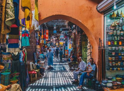 Locals sitting in colourful market medina, Marrakech, Morocco