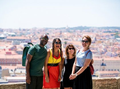 Group of Intrepid travellers laughing with city view in Lisbon, Portugal