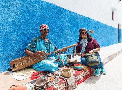 Traveller with local musician on blue street, Rabat, Morocco