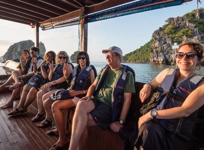 Group of travellers on a boat taking in the sights in Halong Bay on an Intrepid Travel tour