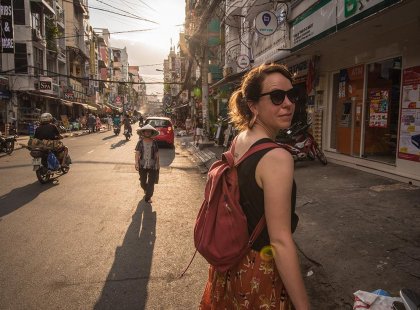 Female traveller walking through the streets of Ho Chi Minh City, Vietnam on an Intrepid Travel tour