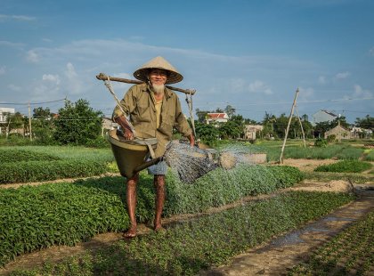 Elderly local man watering his crop in Hue, Vietnam