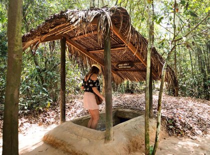A traveller is descending the steps into an entrance to the famous Cu Chi Tunnels used during the war in Ho Chi Minh City, Vietnam.