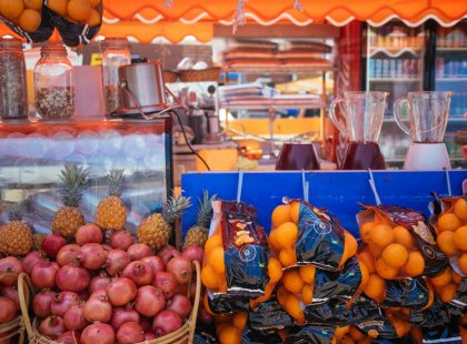 Juice and fruit stand with oranges and pomergranites