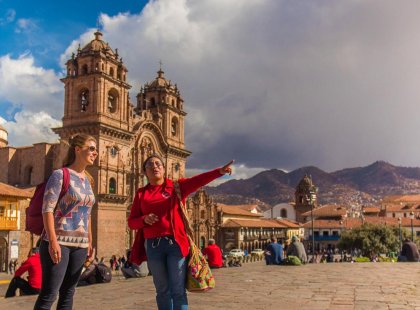 Traveller and tour leader in front of Cathedral, Plaza De Arma, Cusco, Peru