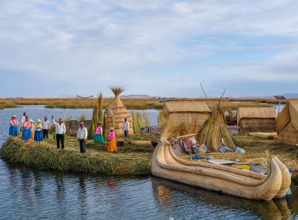 Locals waving welcome on floating island, Lake Titicaca, Peru