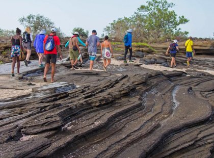 Group walking over volcanic lava formations, Galapagos Islands