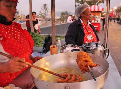 Peruvian women sell fried food on the streets of Lima, Peru