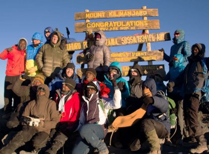 Cheer with joy upon reaching Uhuru (freedom) Peak, the summit of Mount Kilimanjaro.