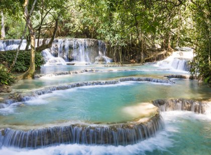 Cycle and hike to the travertine Kuang Si Waterfalls hidden in the lush forests of Northern Laos.