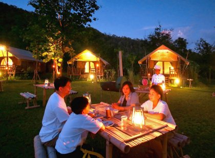 Enjoy a delicious Thai dinner at an open-air restaurant in Kanchanaburi.