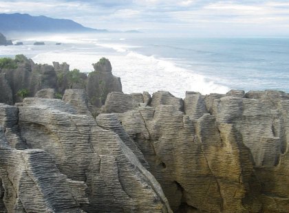 See the magnificent pancake rocks at Punakaiki on New Zealand’s rugged West Coast.