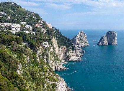 Capri's rugged coastline includes towering rock formations sculpted by wind and sea, sea caves and hidden coves. The Faraglioni, three spurs of rock that rise out of the sea, are one of the most recognizable and captivating sights of the island.