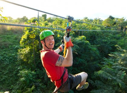 Soar with the birds through the pristine jungle canopy on the longest zip-line course in Belize.