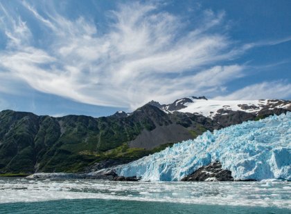 On a scenic cruise in Kenai Fjords, we glide past beautiful tidewater glaciers, marveling at their blue-tinged surfaces and listening to the cracking and groaning of the glacial ice.