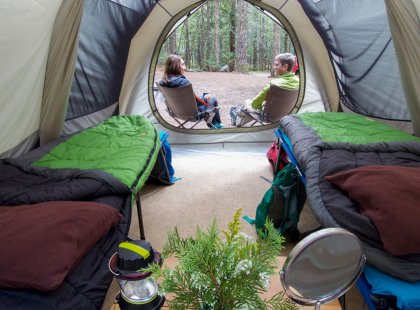Sleep in oversized tents with cots and comfy REI camp furniture.