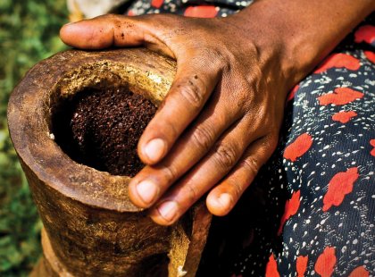 Woman manually grinding coffee in Ethiopia