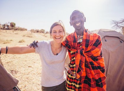 Traveller preparing her tent in Loita Hills with the Maasai tribe, Kenya on an Intrepid Travel tour