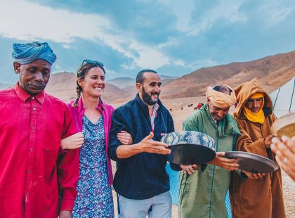 Travellers and local berbers at desert camp, Sahara, Morocco