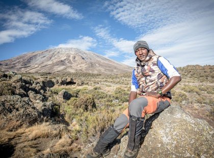 Intrepid tour leader looking out over the summit of Mt Kiliminjaro, Tanzania