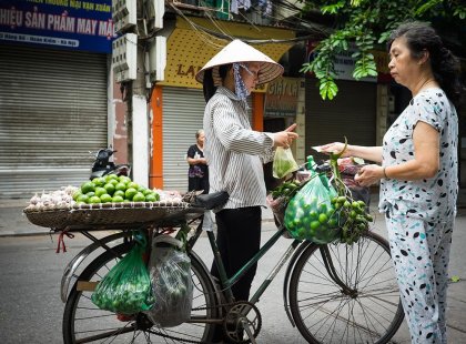 Local fruit vendor selling produce to a local woman in Hanoi, Vietnam