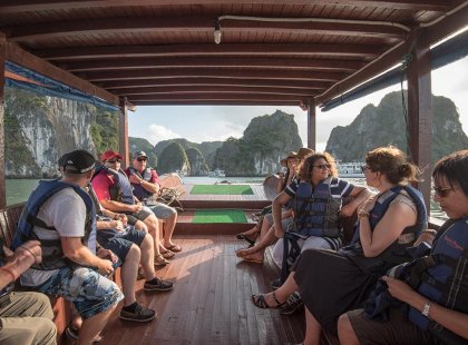 Group of travellers on a boat ride through Halong Bay, Vietnam on an Intrepid Travel tour.