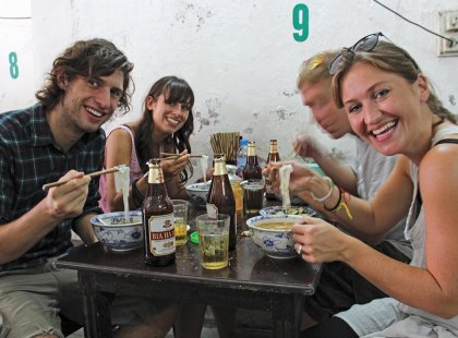 Group eating noodles in Hanoi, Vietnam