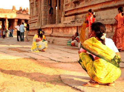 india hampi ruins local woman crouches