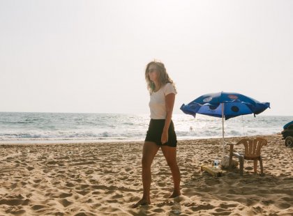 Traveller walking along the sun-kissed beach in Goa, India on an Intrepid Travel tour.