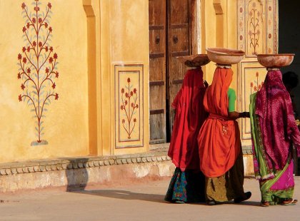 Local women carrying baskets on their head as they walk past Amber Fort in Jaipur, India