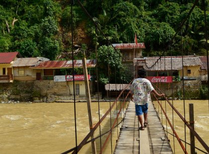 Man walking across Bukit Lawang bridge