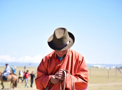 Intrepid Travel mongolia local texting on horse