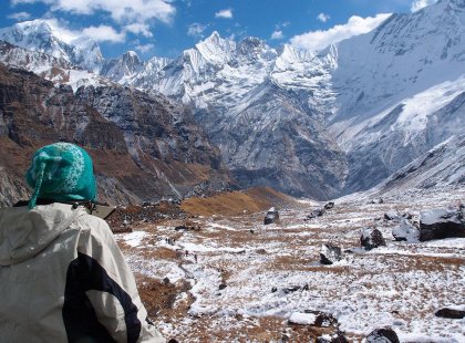 Woman sitting and enjoying the view of the Annapurna Ranges in Nepal.
