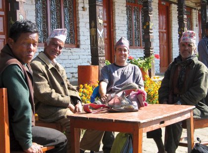 Traveller conversing with locals at a table in Annapurna, Nepal