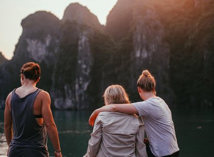 Travellers enjoying a sunset at Halong Bay, Vietnam on an Intrepid Travel tour.