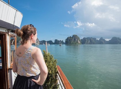 Woman looking on from a boat to Halong Bay on an Intrepid Travel tour.