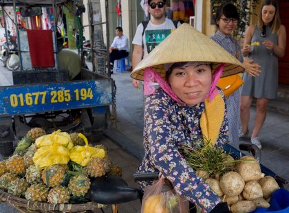 Local fruit vendor selling fresh fruit to Intrepid Travel passengers in Hanoi, Vietnam.