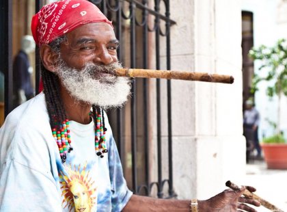 A local smokes a traditional hand-rolled cigar on the streets of Havana, Cuba