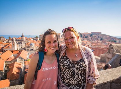 Intrepid travellers smiling with view of Dubrovnik old town red rooftops, Croatia