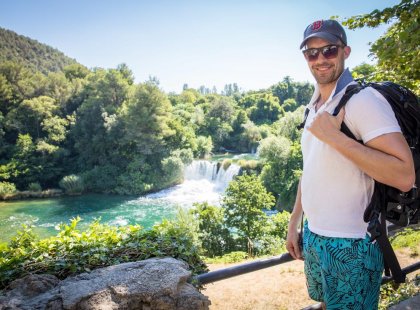 A traveler infron of a waterfall at Krka National park