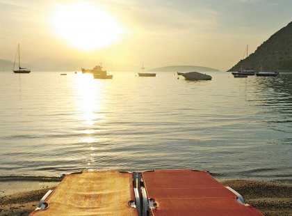 greece sunset beach chairs boats ocean