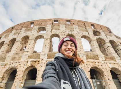 Traveller taking a selfing in front of the Colosseum in Rome, Italy.