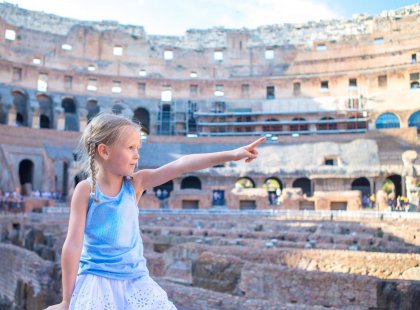 Little girl sitting in-front of colosseum, rome, italy