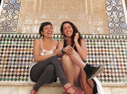 Intrepid Travellers sitting on steps in front of mosaic wall, Granada, Spain