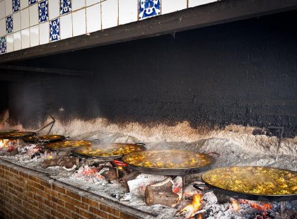 Specialty venue cooking numerous large pans full of paella in Spain.