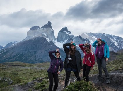 Travellers with horns hands gesture in the Torres del Paine National Park, Patagonia on an Intrepid Travel tour.