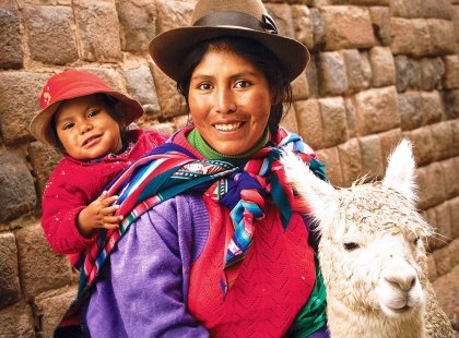 Mother and child in traditional dress with llama, Cusco, Peru